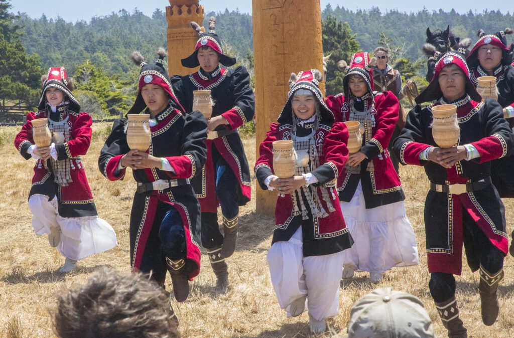 Seven dancers dressed in traditional Siberan attire.